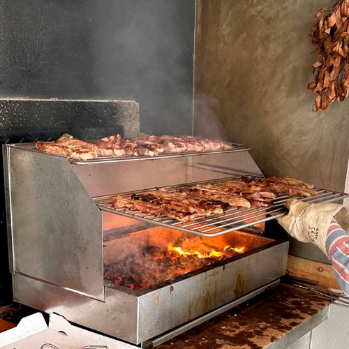 Grilloir barbecue à poser 70 cm Premium en utilisation extérieure avec braises et grillades