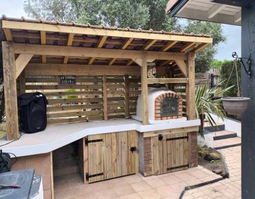 Four à pizza au feu de bois 90 cm installé dans une cuisine d’été
